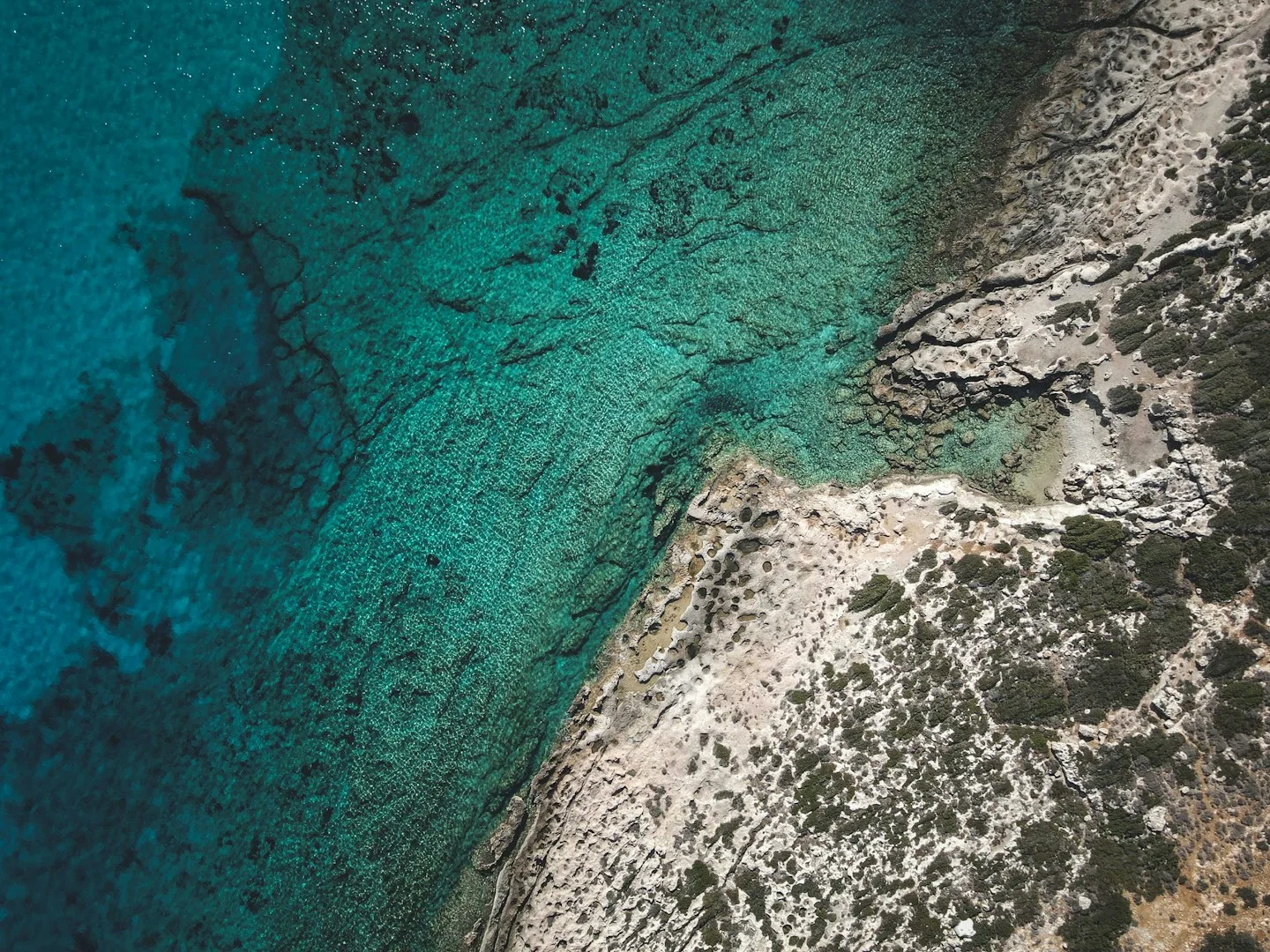 Sample aerial photograph of turquoise water meeting a rocky coastline